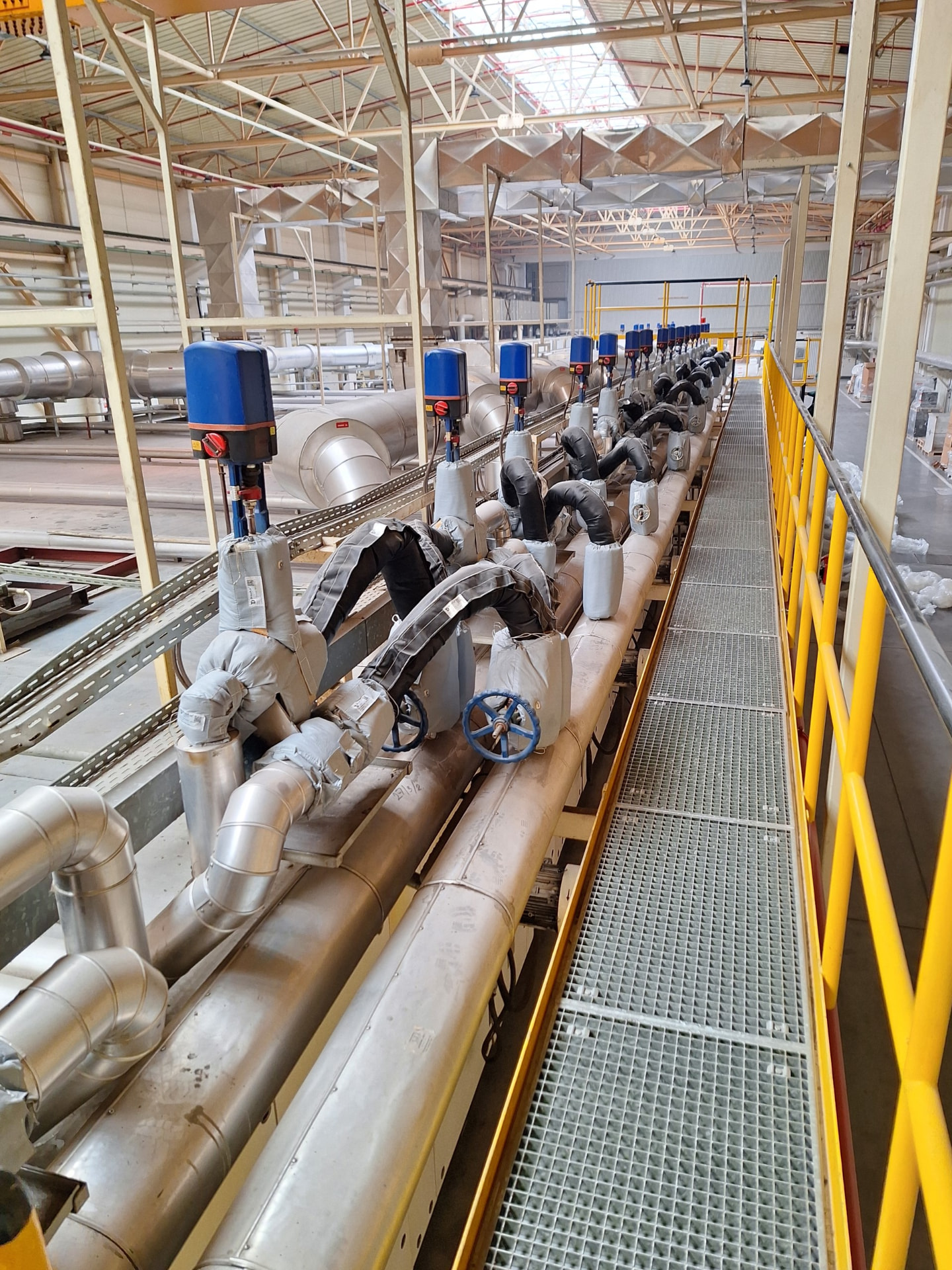 Rând de armături izolate pentru ulei termic într-o hală industrială